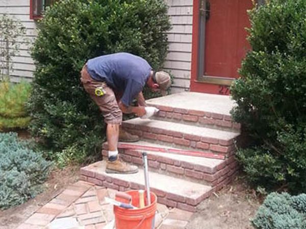 Image of a Well Done Landscapes worker performing masonry repair in Lakeville.