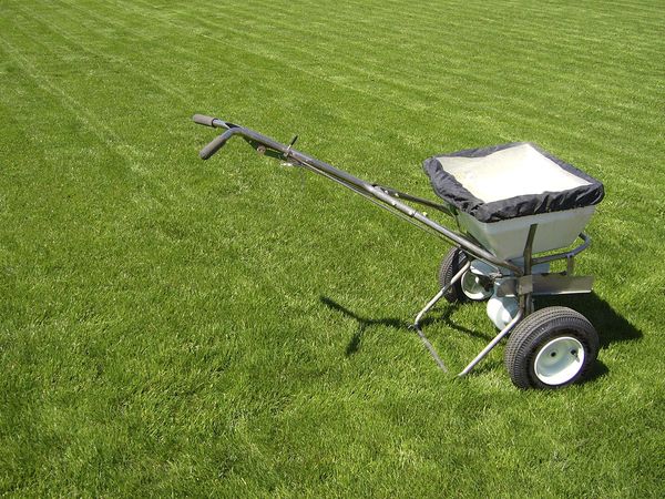 Fertilizer trailer filled to the top sitting on a green lawn