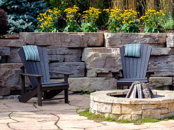 Image of a backyard patio with two chairs and a fire pit.