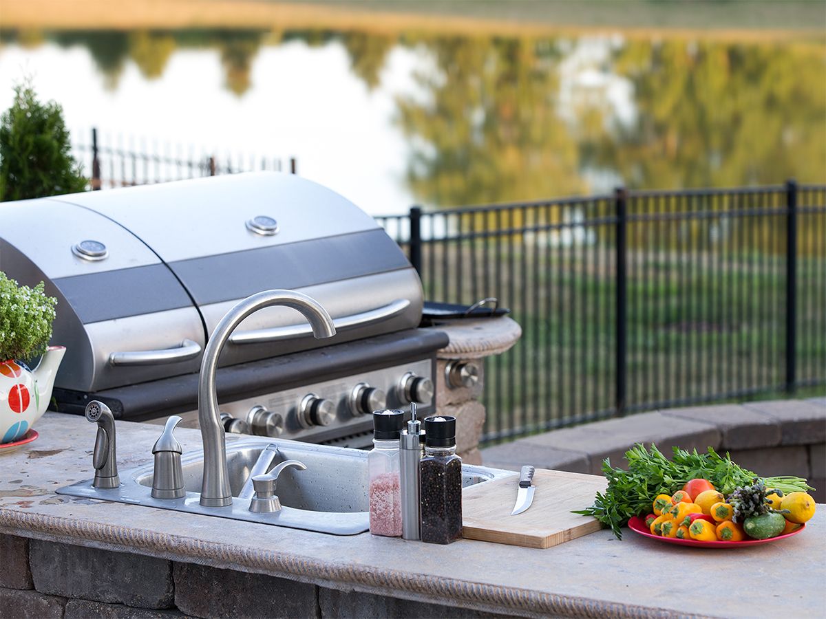 Image of an outdoor kitchen area with a sink and a grill.