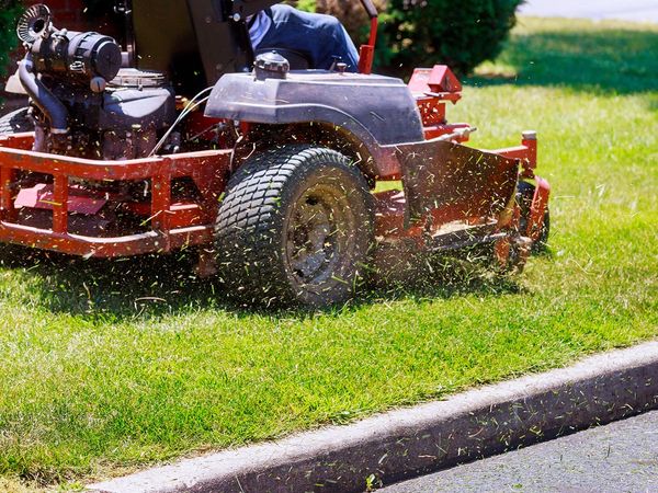 Riding lawn mower going over grass