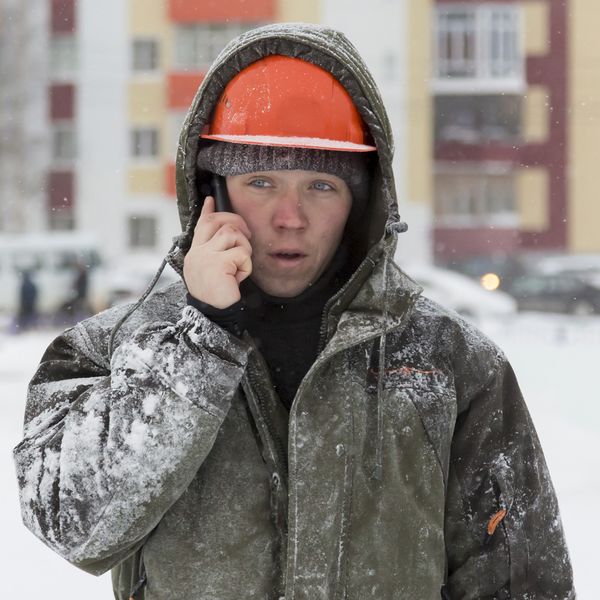 Worker in the snow talking on the phone