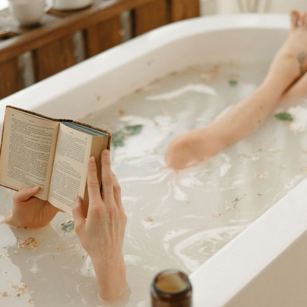 woman taking bath and reading