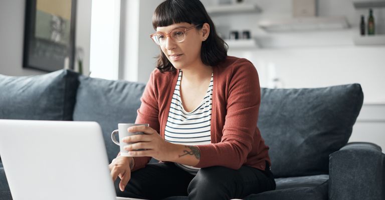 A woman thoughtfully considers her birth control options in a calm, sunlit room.