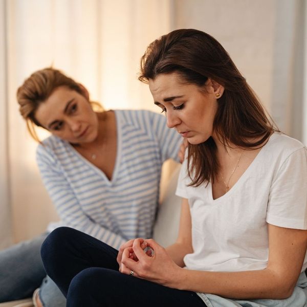 A woman comfrting her friend.