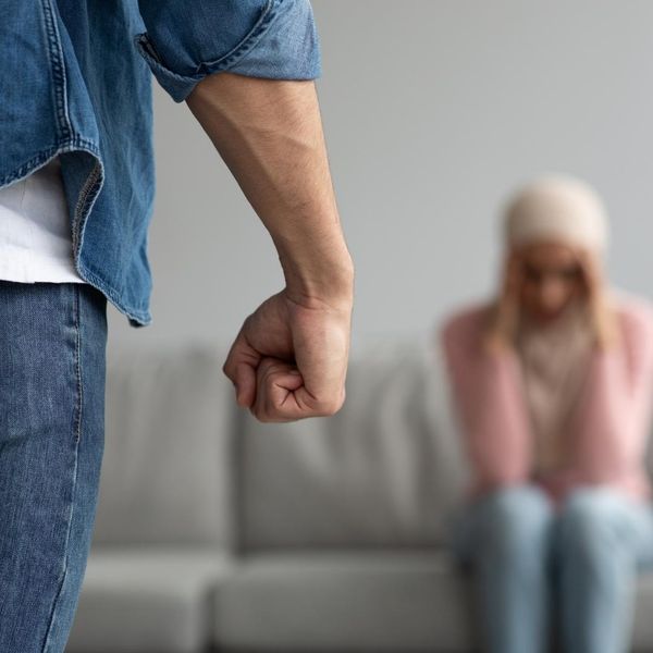 Man with clenched fist and woman afraid