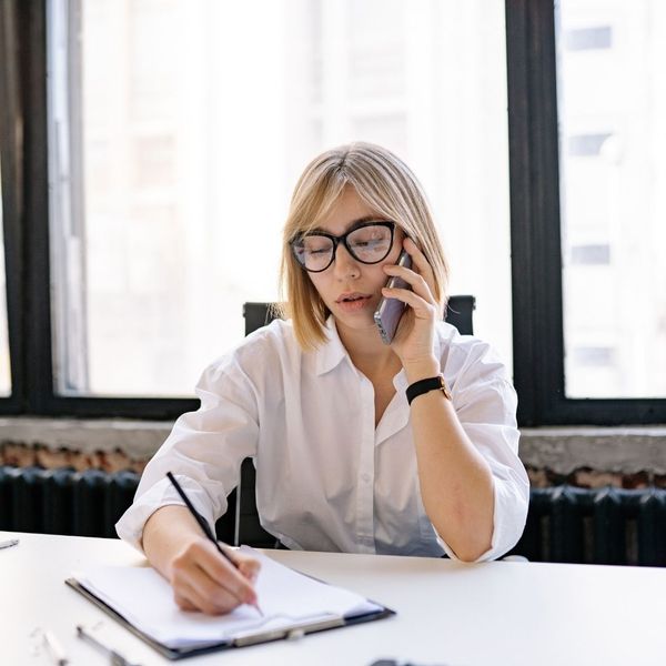 woman on phone taking notes