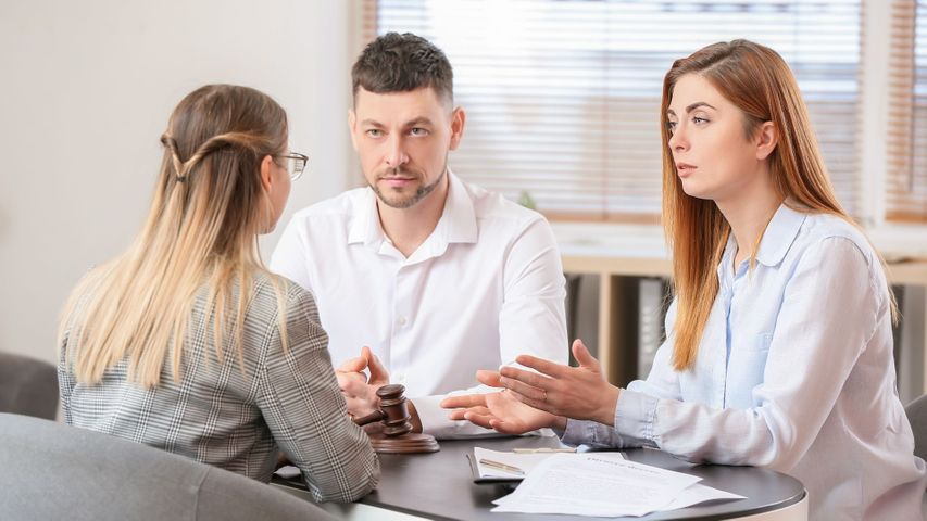 Female lawyer having a discussion with a man and woman. 