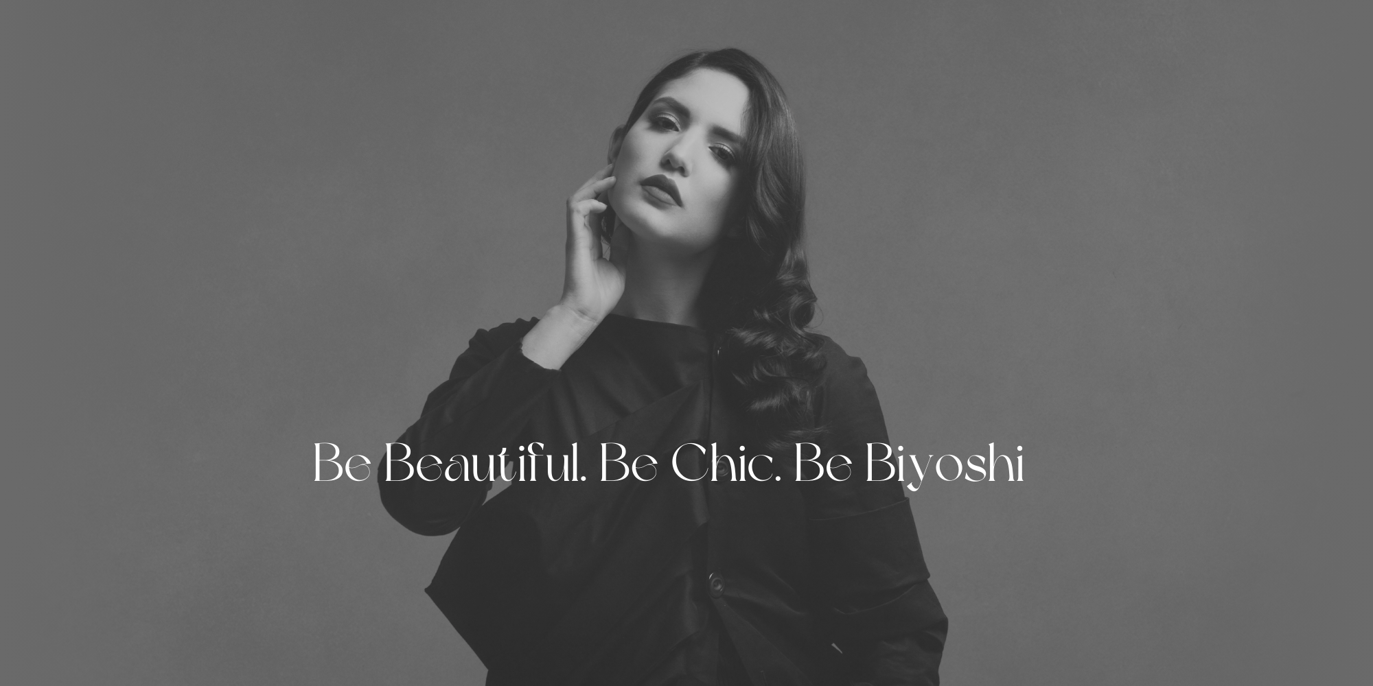Black and white photo of model with black hair styled in waves. Salon Biyoshi Knoxville Hair Salon