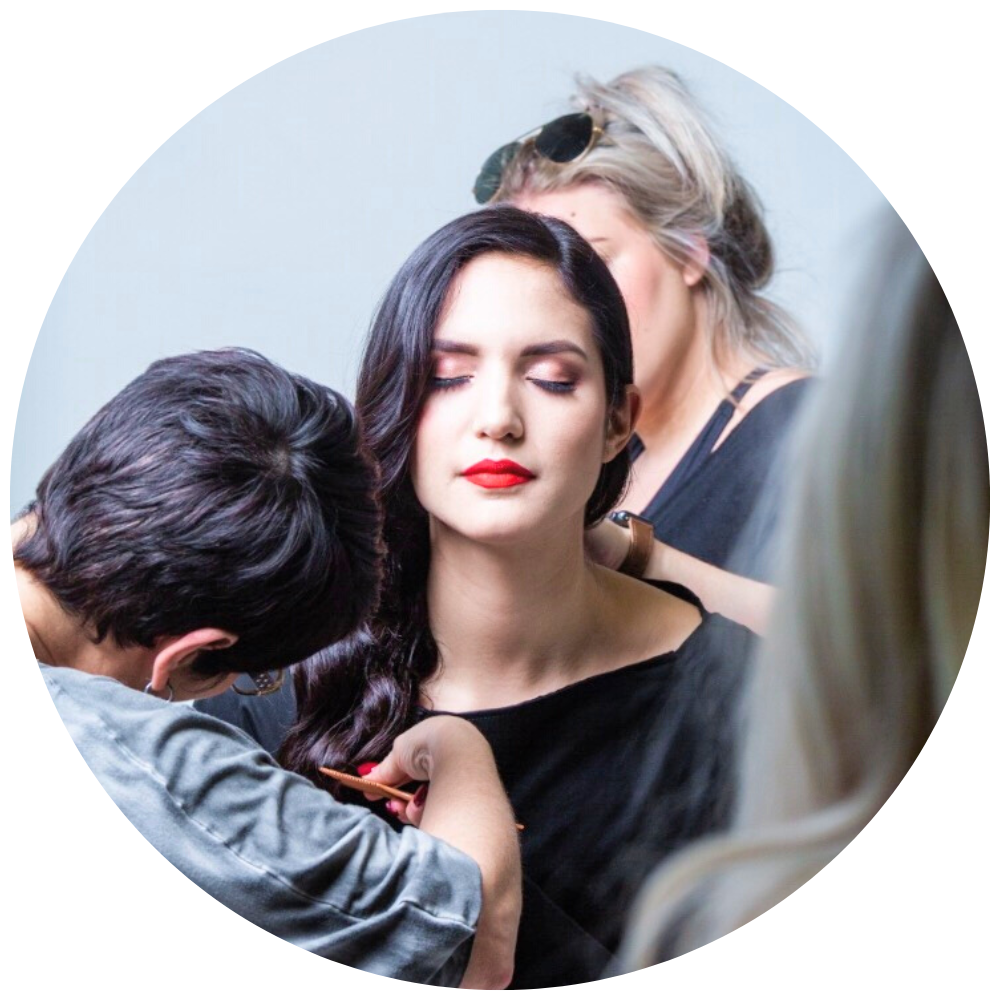 Several stylists making over a model with black wavy hair. Salon Biyoshi Careers
