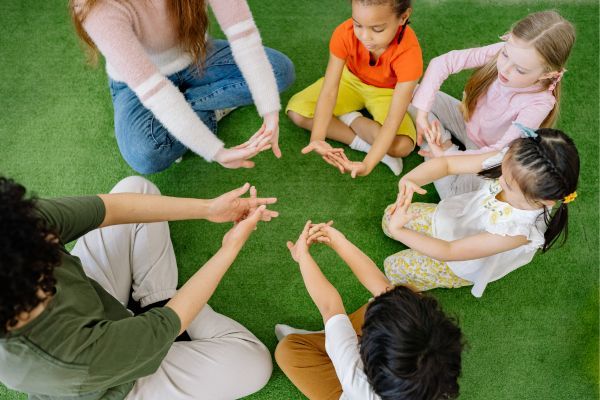 students sitting in circle with teacher 