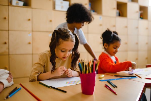 kids using colored pencils in classroom