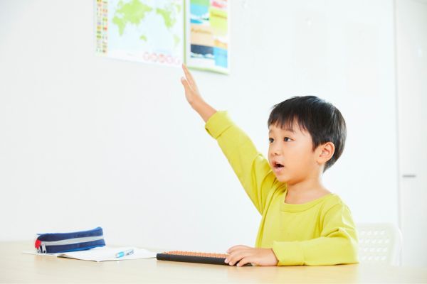 boy raising hand in classroom