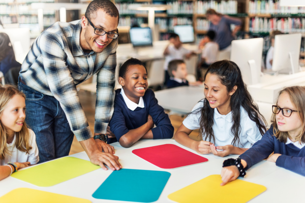 students at table with teacher 