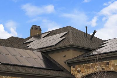 A modern home with sleek, black solar panels professionally installed on its dark shingle roof. A modern home with sleek, black solar panels professionally installed on its dark shingle roof.