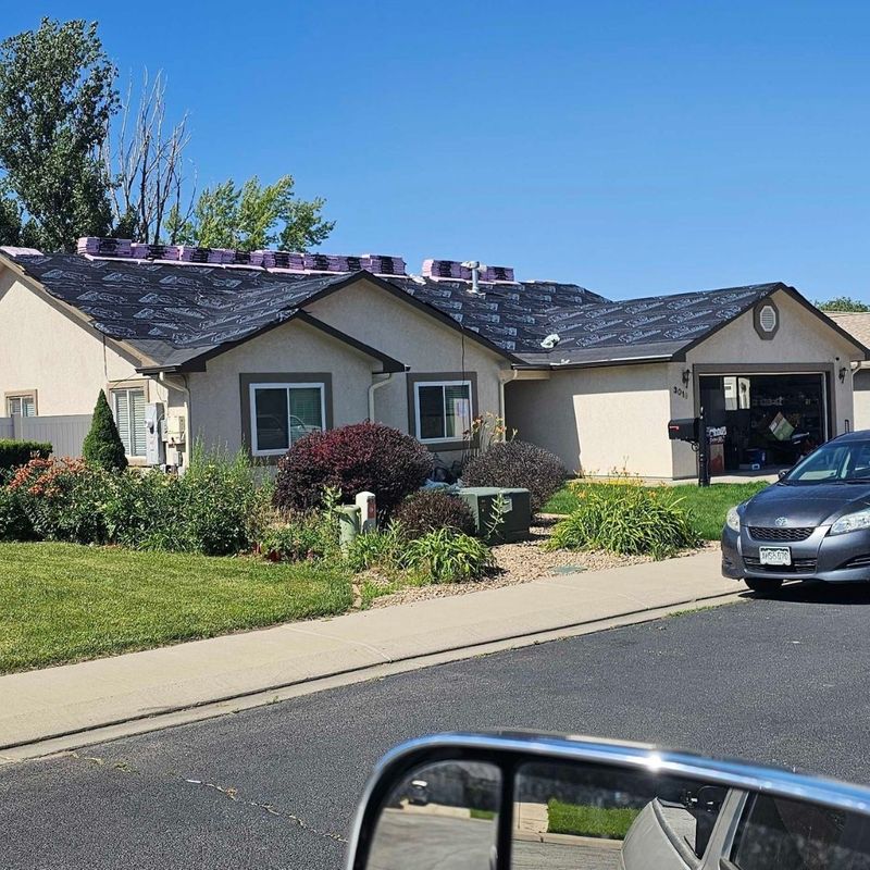 A residential home with new roofing underlayment installed, prepared for a full shingle replacement.