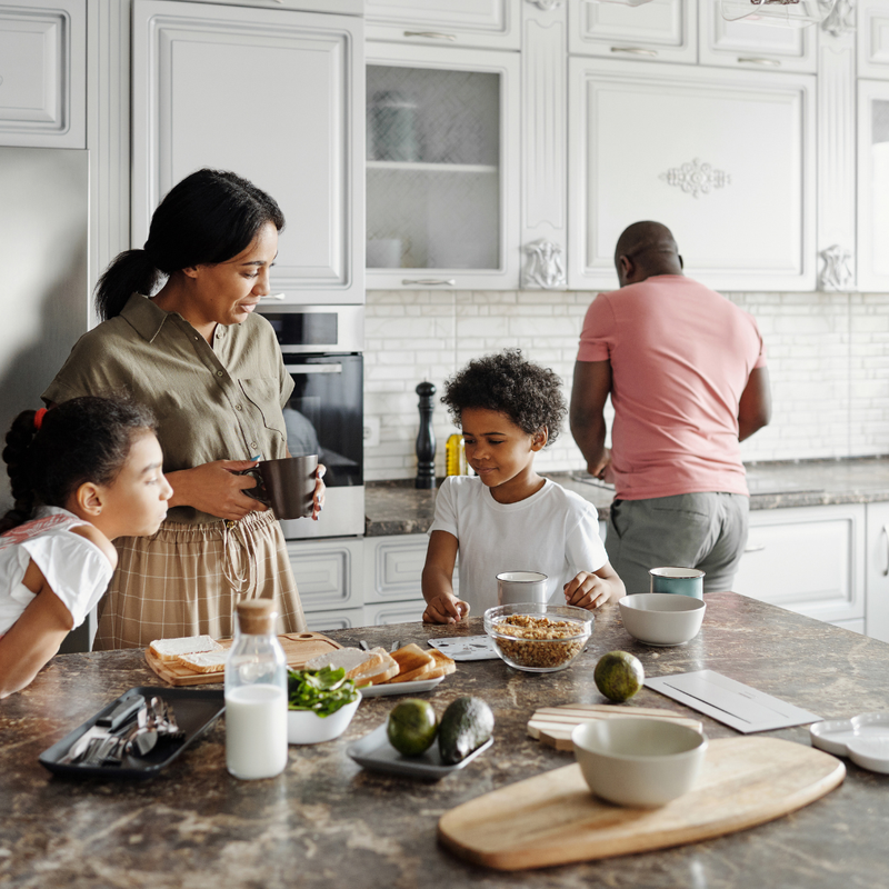 family happily making breakfast around the kitchen island