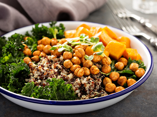 Green and healthy vegan grain bowl with quinoa, butternut squash, kale and roasted chickpeas