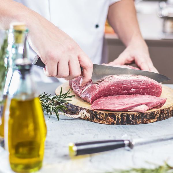 image of a chef slicing steak on a wood cutting board