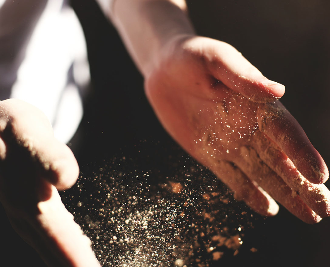 Two hands with spices falling between them.