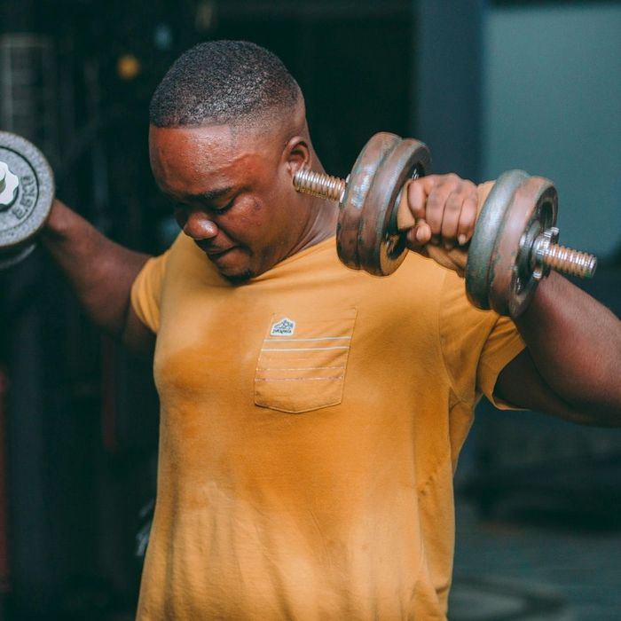 man lifting weights and sweating