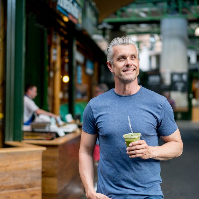 smiling man drinking a smoothie