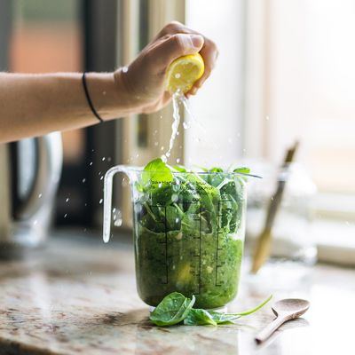 preparing a healthy recipe with spinach and lemon juice