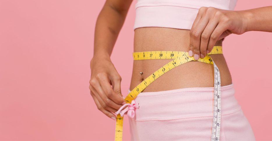 a woman measuring their waist