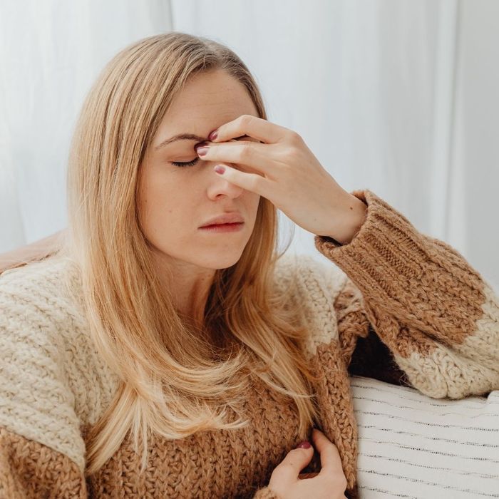 woman pinching nose with headache 