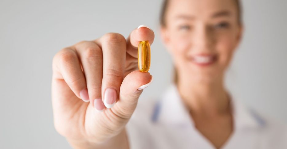 woman holding a vitamin supplement 