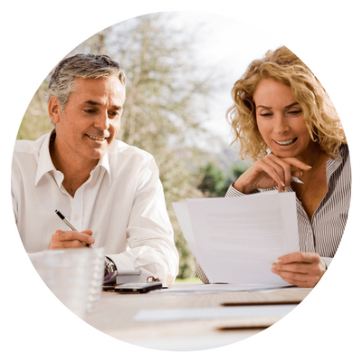 Two people discussing documents outdoors, smiling