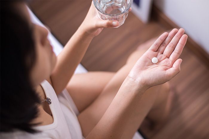 Woman with a pill in her hand