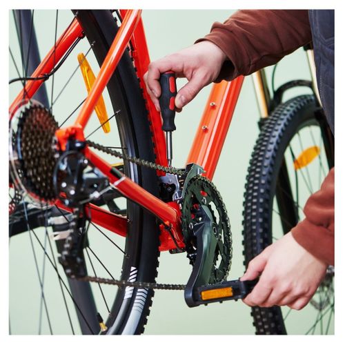 A cyclist riding repairing his chain