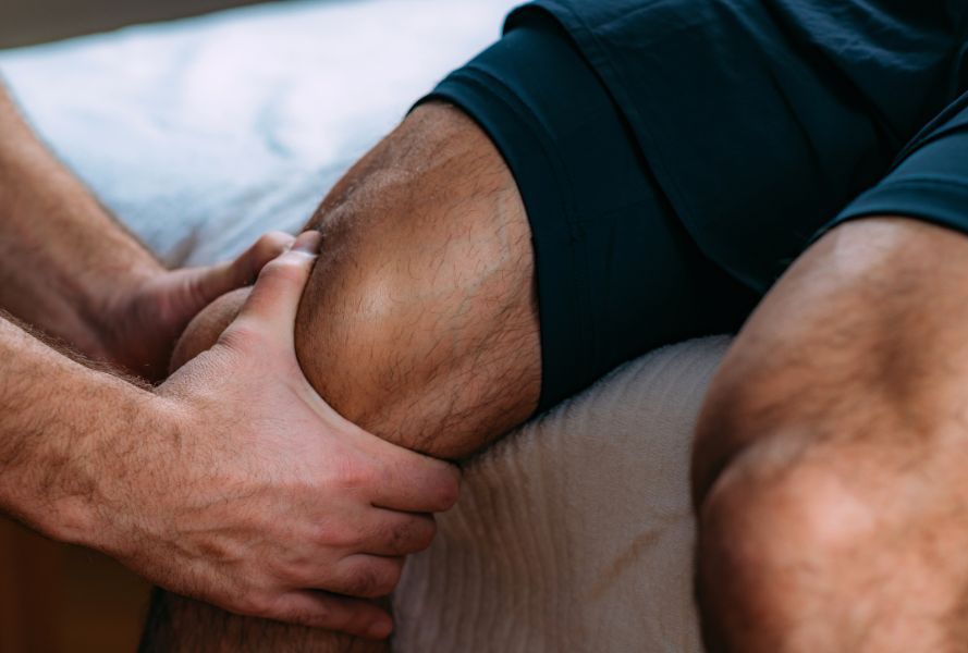 close up of physical therapist massaging athletes knee