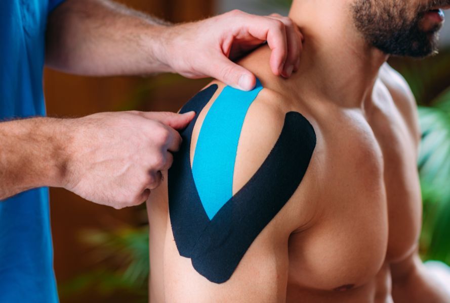 physical therapist taping athletes shoulder