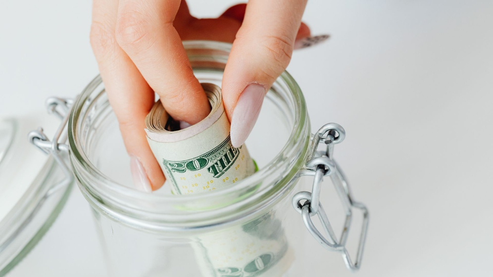person putting money in a container