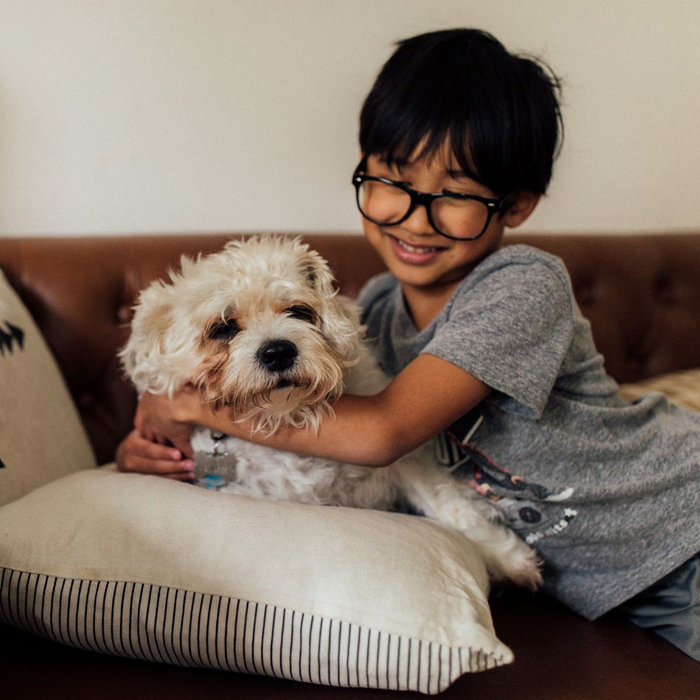 child cuddling his dog