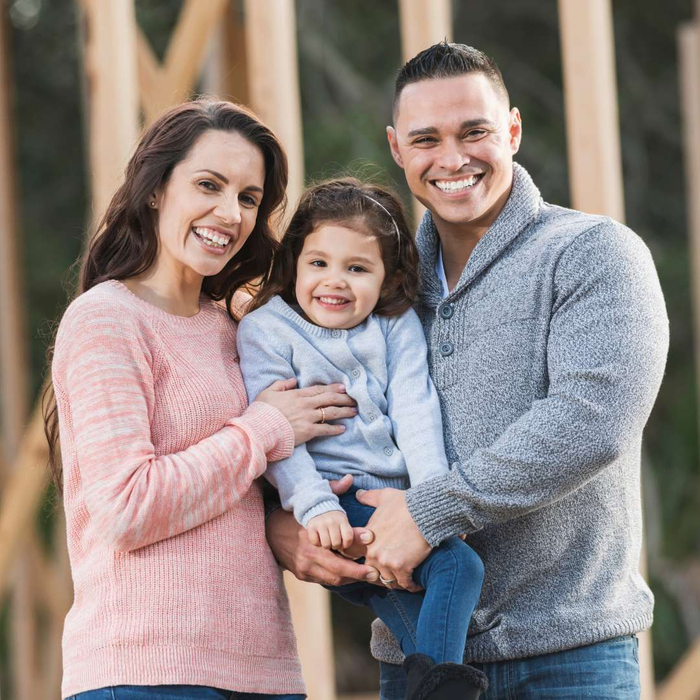 happy family in front of home in progress