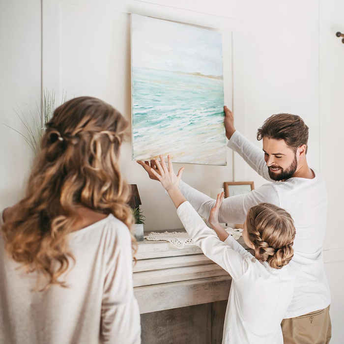 Family hanging artwork on the wall