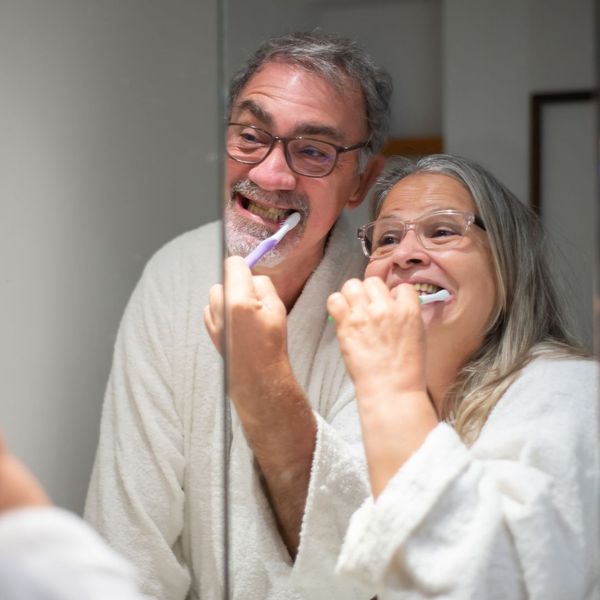 elderly couple brushing teeth
