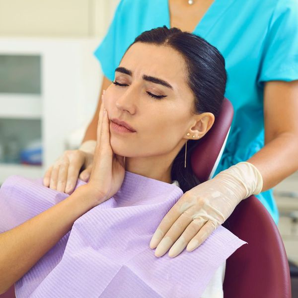 person touching face with tooth pain person touching face with tooth pain