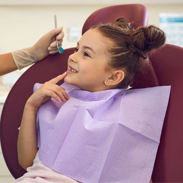 young girl smiling in dentist chair