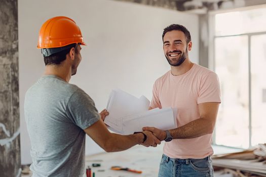 Smiling construction leader on-site wearing hard hat, representing Stride Pro Builders hands-on leadership from start to finish.