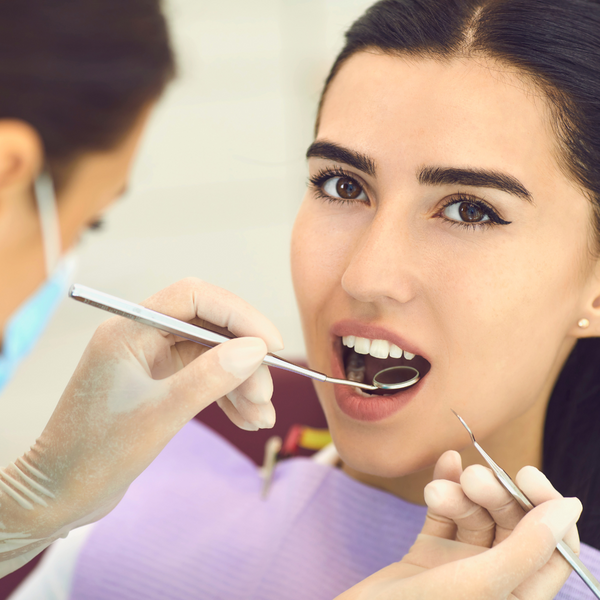 A dentist inspecting a patients mouth