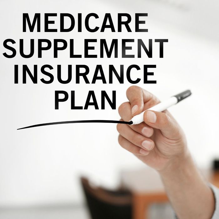 Image of a person writing the words: Medicare supplement Insurance plan.