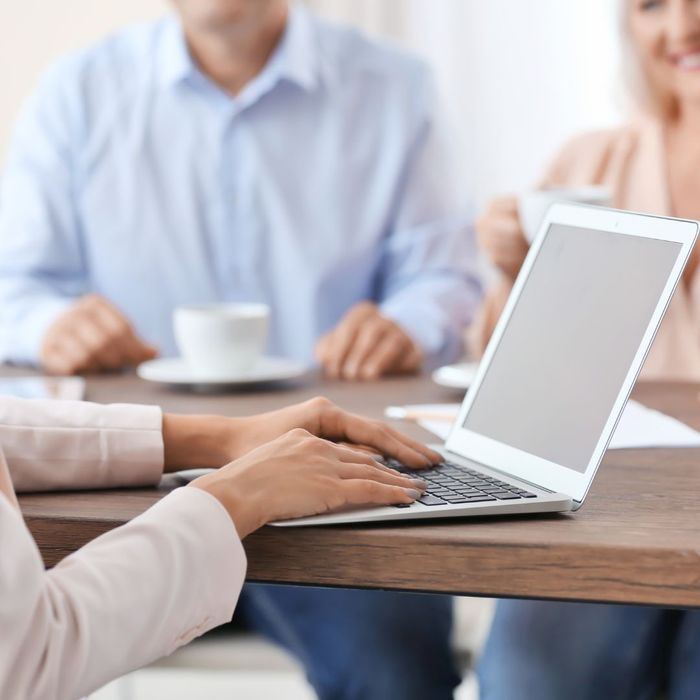 Image of a woman with a laptop sitting across from two other people