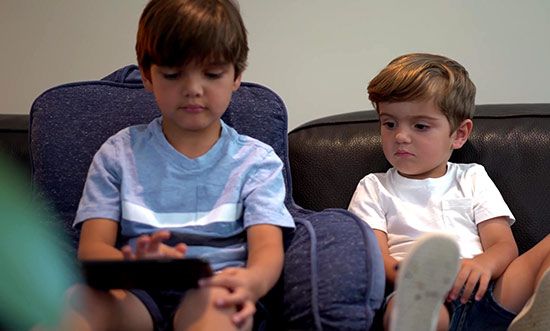 Two young boys looking at a smartphone