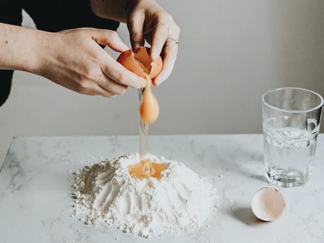 cracked egg falling into baking flower