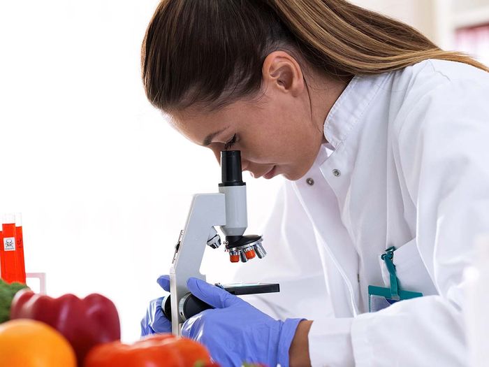 woman looking into microscope