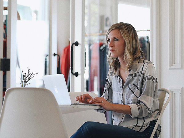 Woman working on laptop, using templates from the service